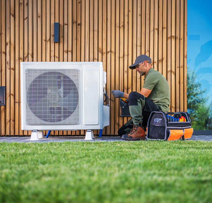 Contractor installing a heat pump outside a home